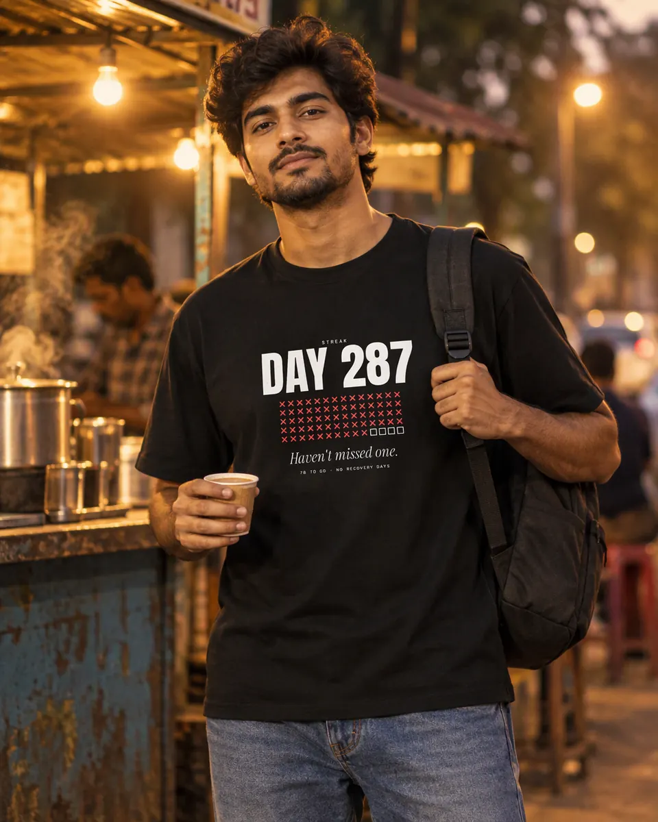 Man with a cup of chai at a street stall at night in the Day 287 tee