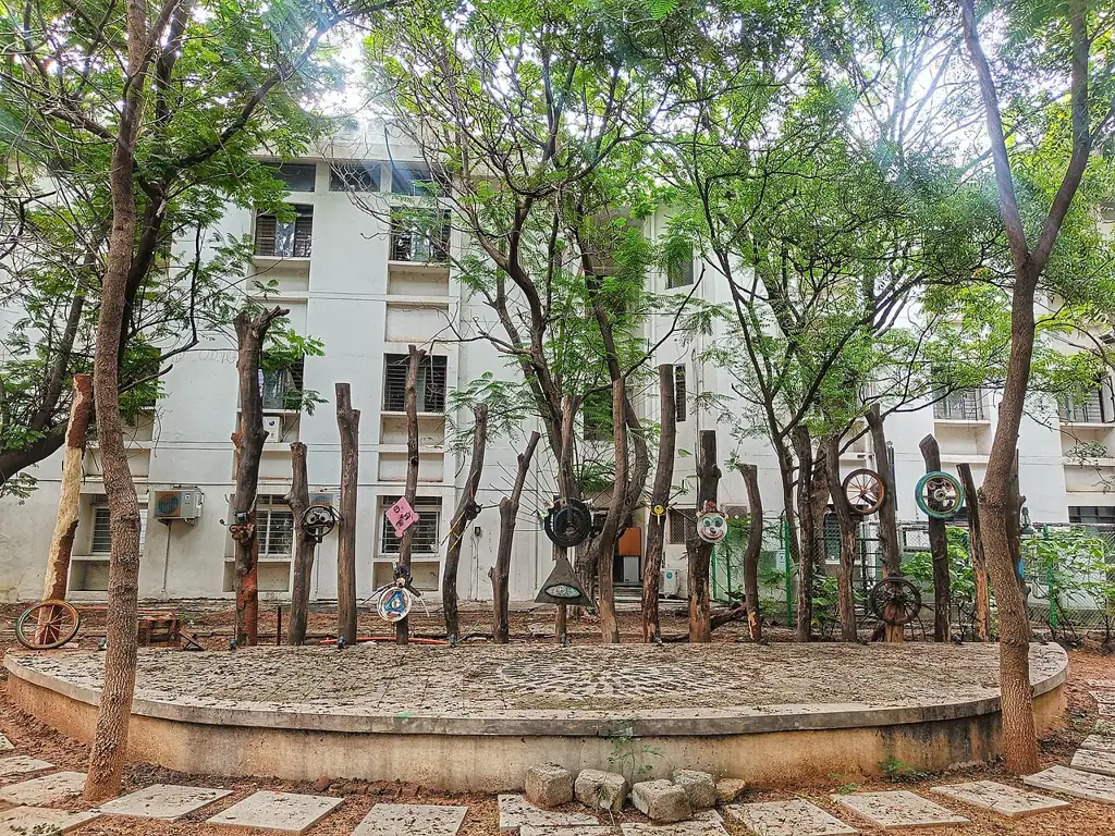 Small amphitheatre built from wood logs and scrap metal in front of a residential block at IIT Hyderabad