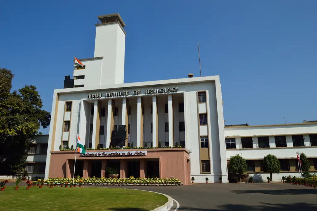 The Main Building of IIT Kharagpur, a long red-brick building with a central clock tower, under a clear sky