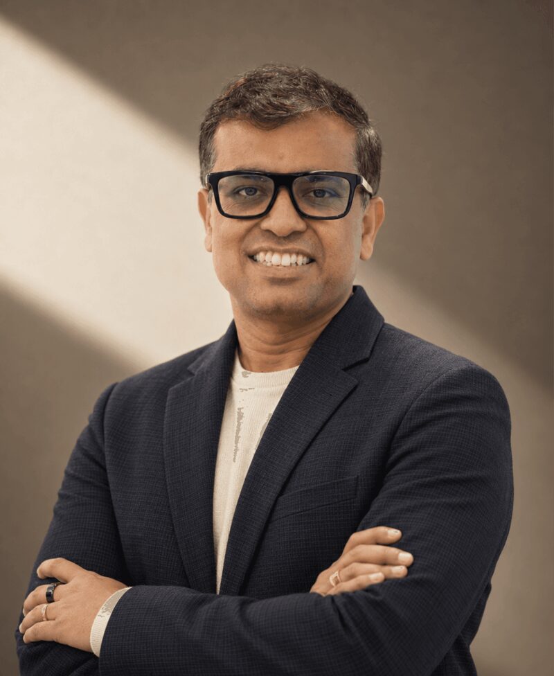 Surojit Chatterjee, co-founder and CEO of Ema, in a navy blazer with arms crossed
